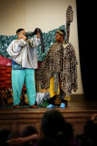 Two men on stage performing a skit for the audience.